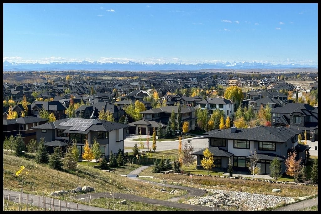 An image showing an upscale neighbourhood in Calgary with the Rocky Mountains in the distance.