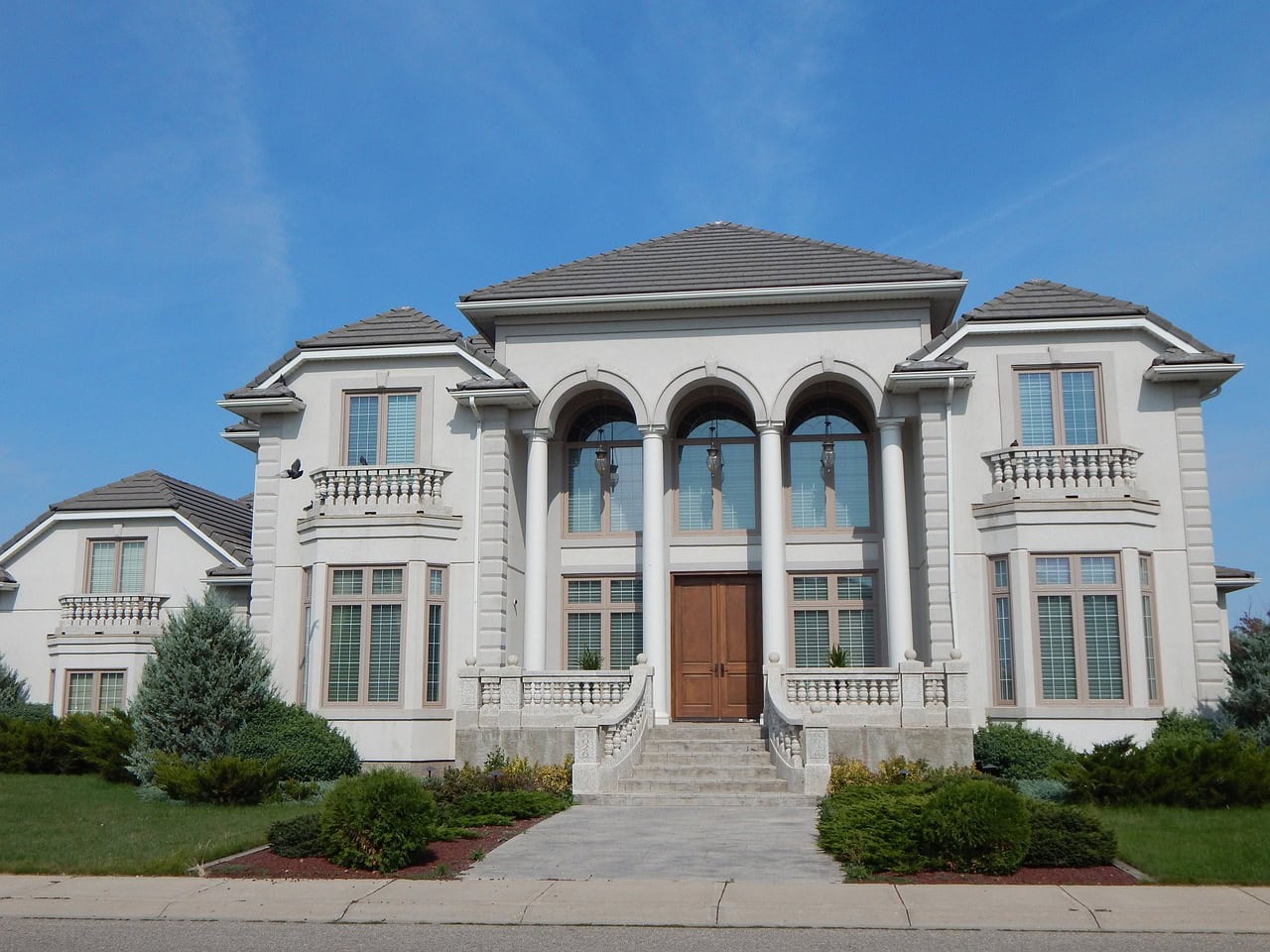 Exterior of a luxury estate home in Calgary, showcasing upscale architecture and manicured landscaping in a premier neighborhood.