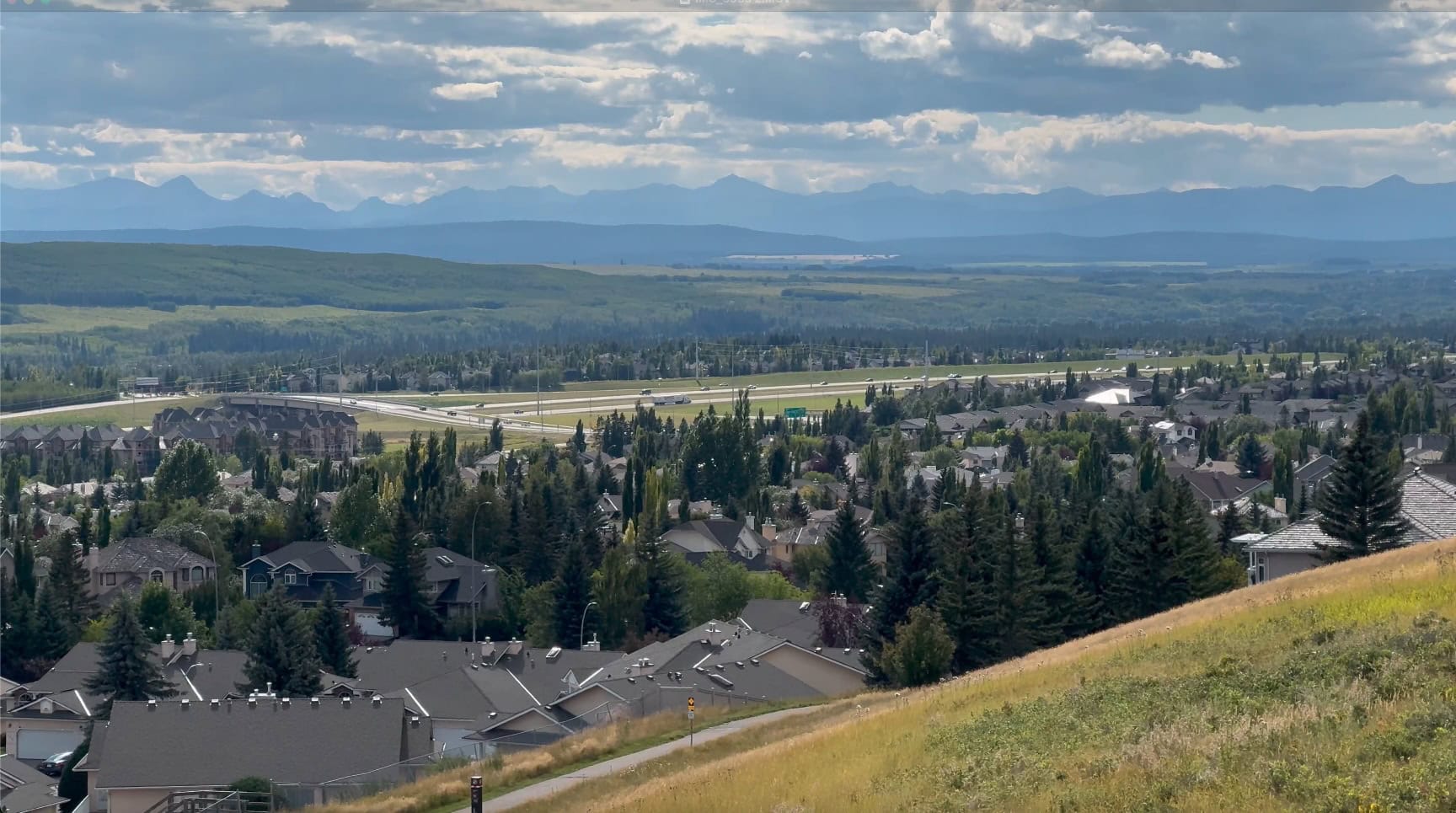 Panoramic view of Signal Hill neighborhood in Calgary featuring residential homes and shopping access