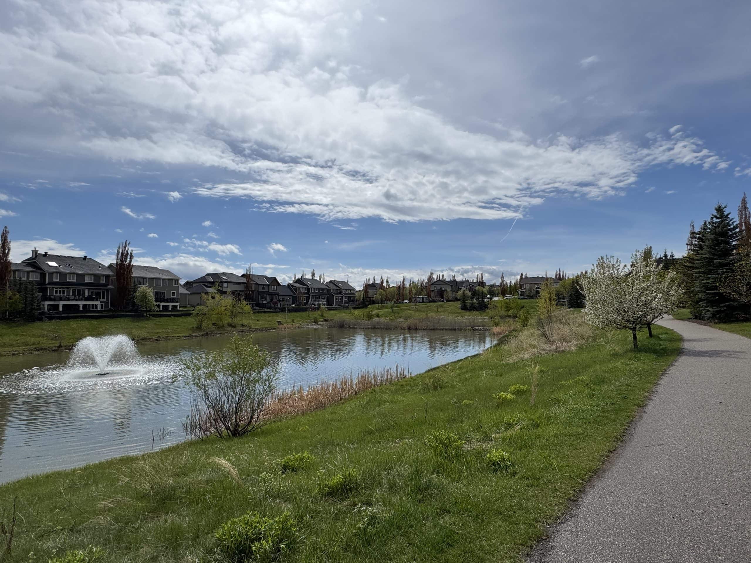 A scenic landscape of West Springs featuring manicured walking trails and modern luxury homes.