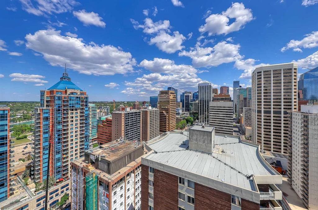 High-rise condos in downtown Calgary under a bright blue sky — a prime area where some condo values are holding strong in 2025 despite rising inventory city-wide.