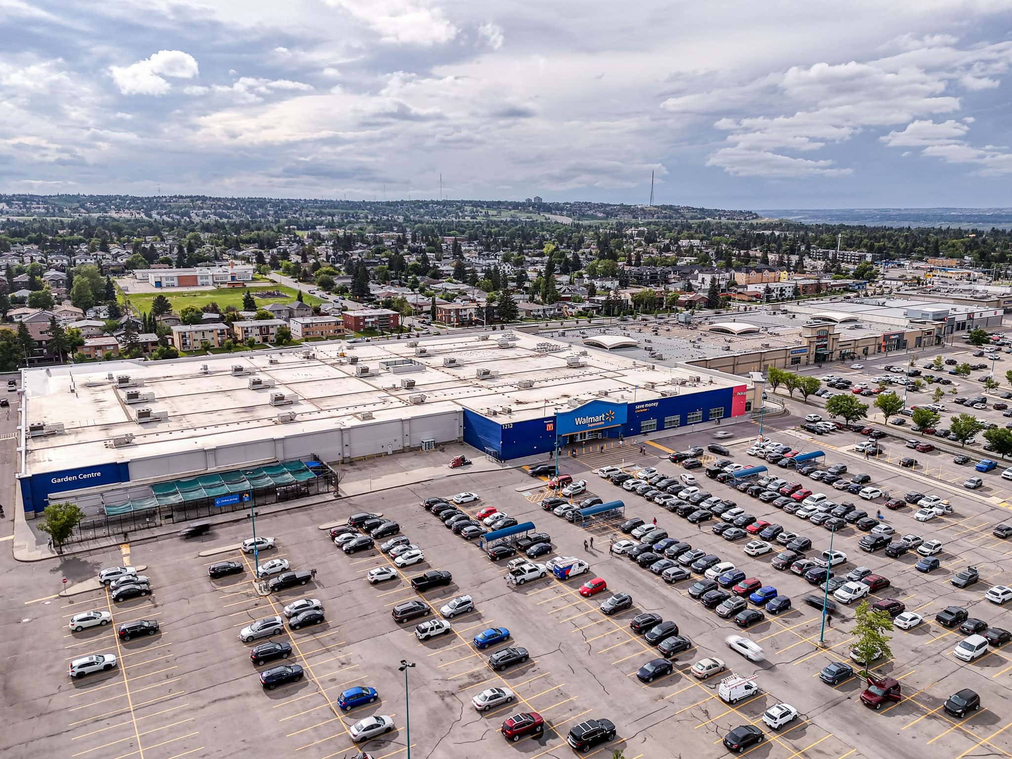 Large retail complex in Killarney Calgary featuring Walmart and ample parking, offering residents convenient access to shopping and essential services.