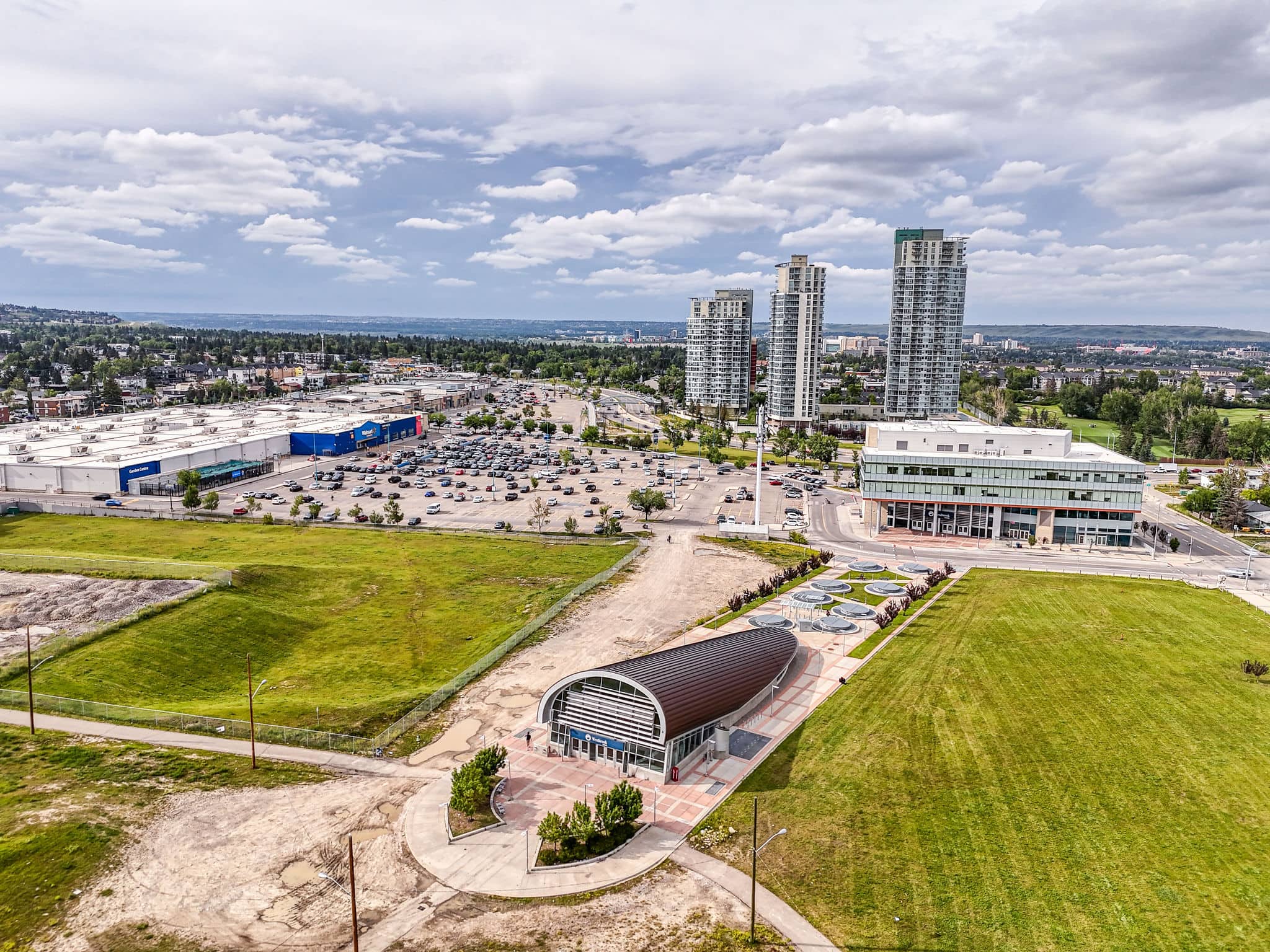 Modern Killarney Calgary landscape featuring high-rise condos, retail centres, and the Westbrook LRT station, offering residents urban living with easy transit access.