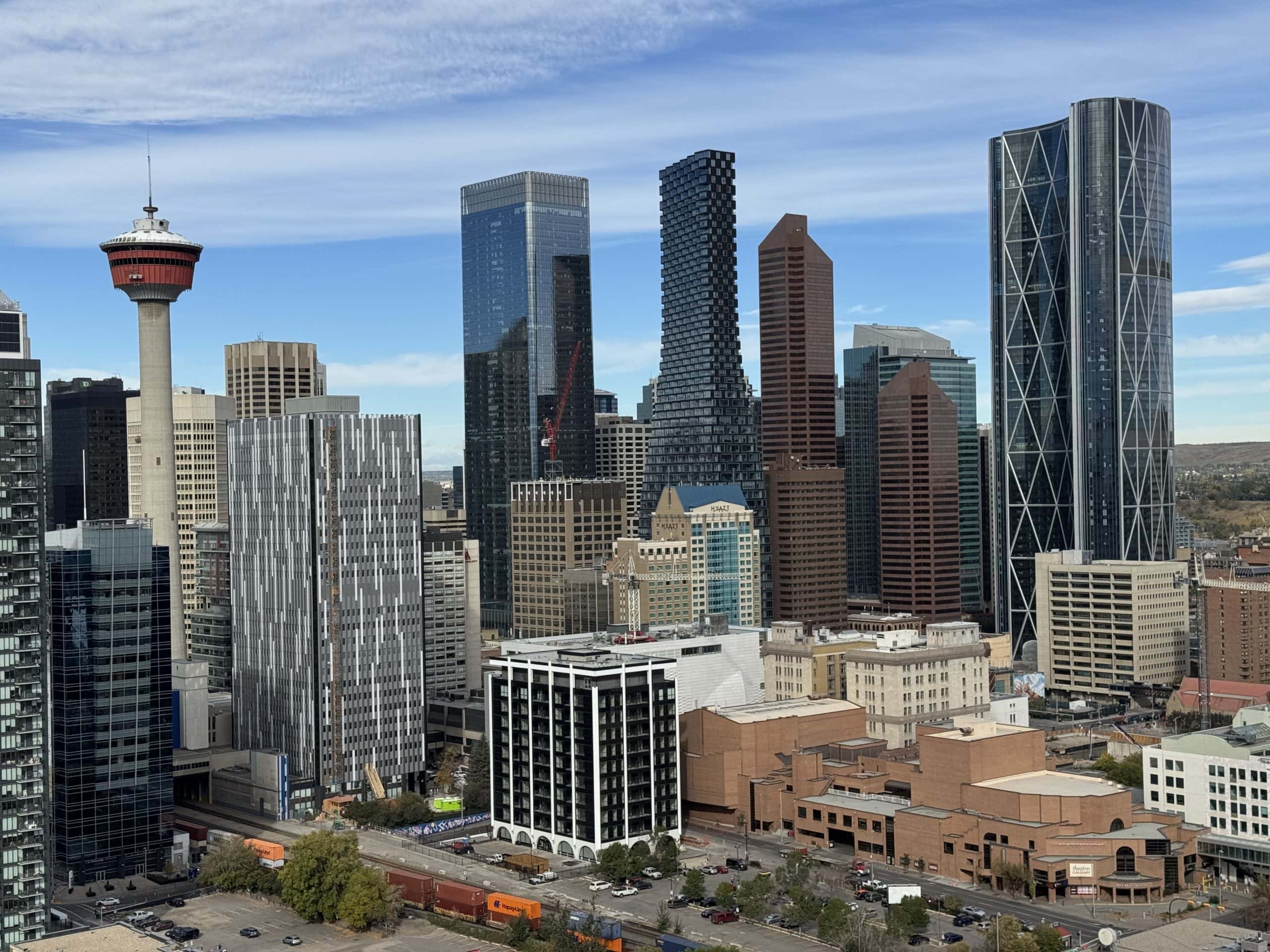 Downtown Calgary skyline with the Calgary Tower and modern skyscrapers under a clear blue sky.