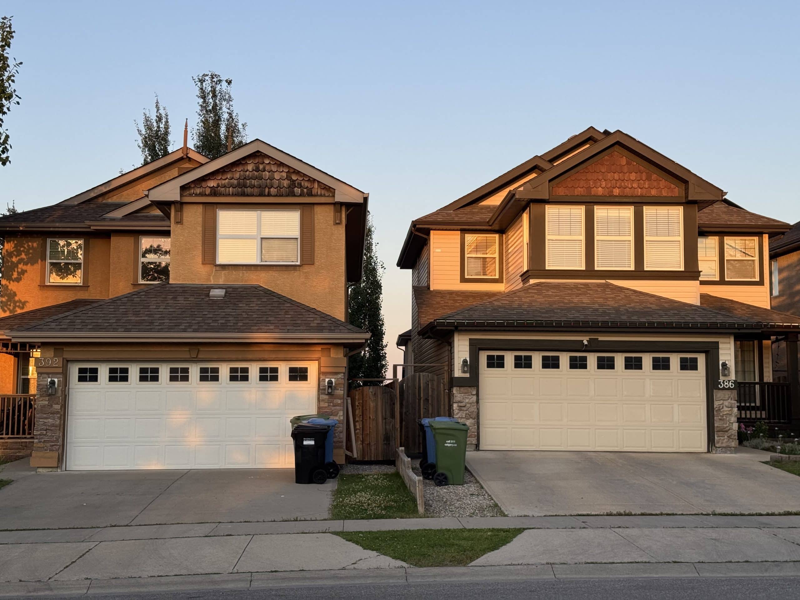 Modern family homes in Evergreen Calgary with double garages and warm evening sunlight, representing the neighbourhood’s inviting suburban character and well kept streets.