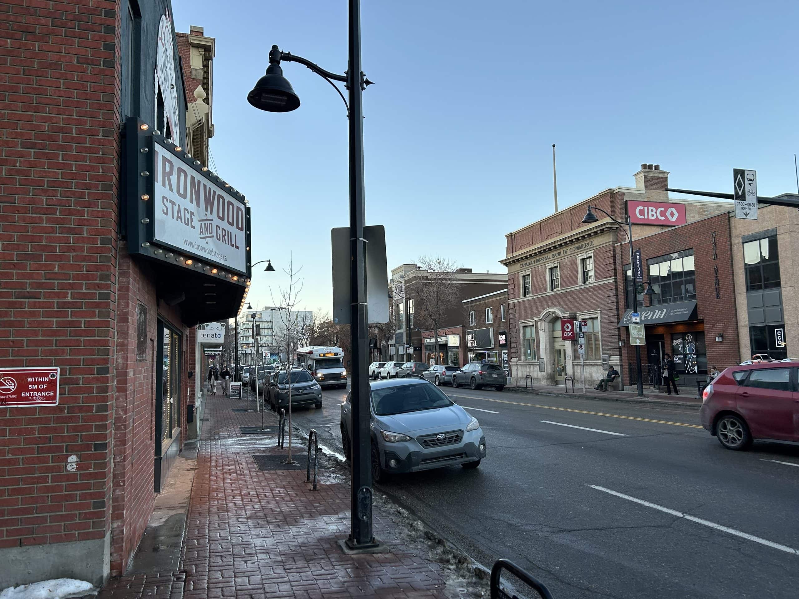 Street view of Calgary’s vibrant Inglewood district, featuring the Ironwood Stage and Grill, historic brick buildings, and local shops along 9th Avenue.