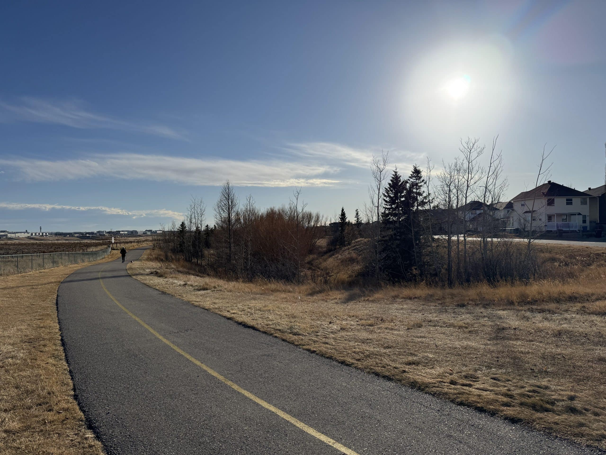 Walking and cycling path in Coventry Hills Calgary on a sunny day, highlighting the community’s access to green space and family-friendly outdoor recreation.