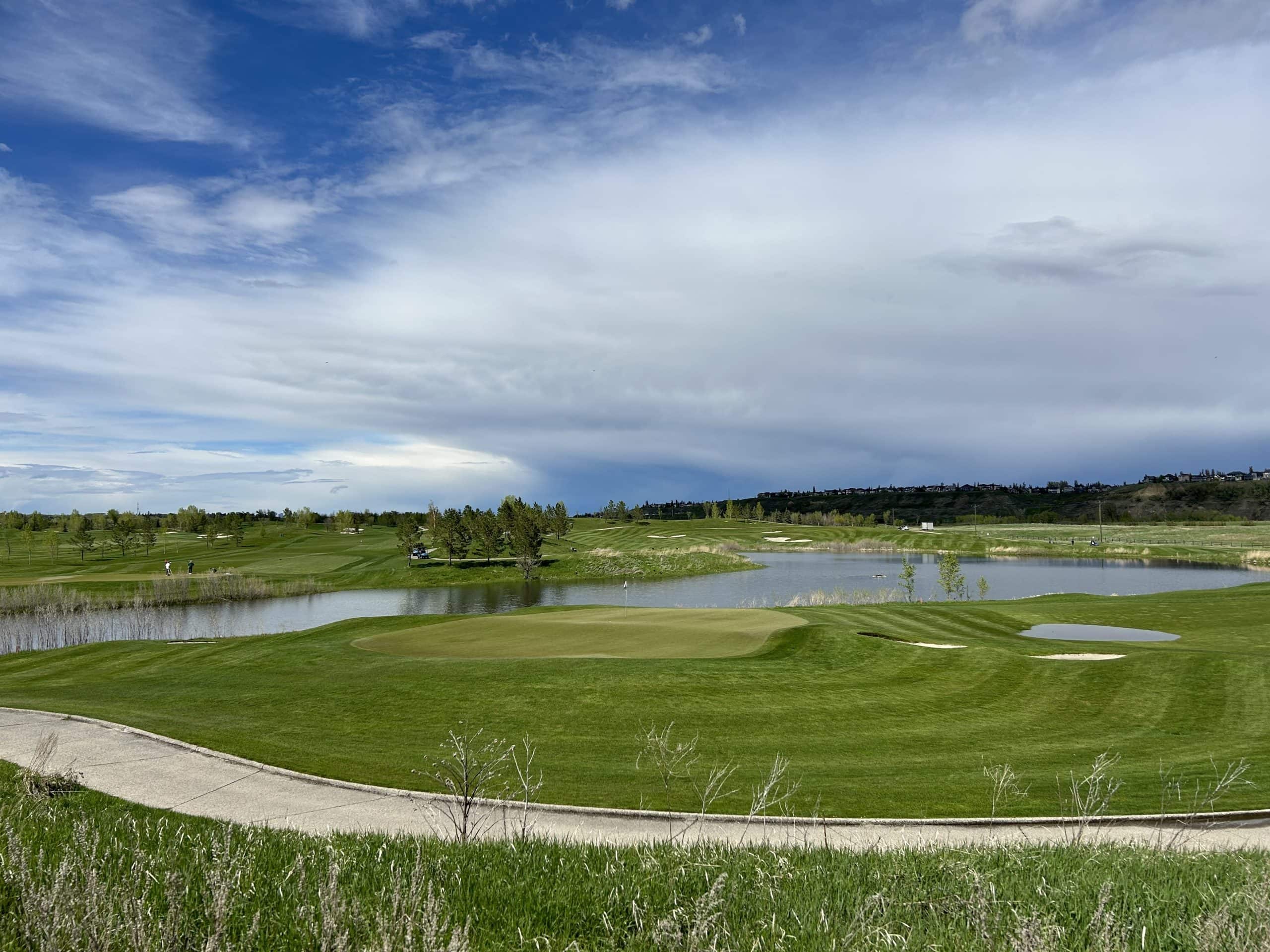 Scenic view of Blue Devil Golf Course in Calgary showing lush fairways, water features, and wide open greens under a bright sky.