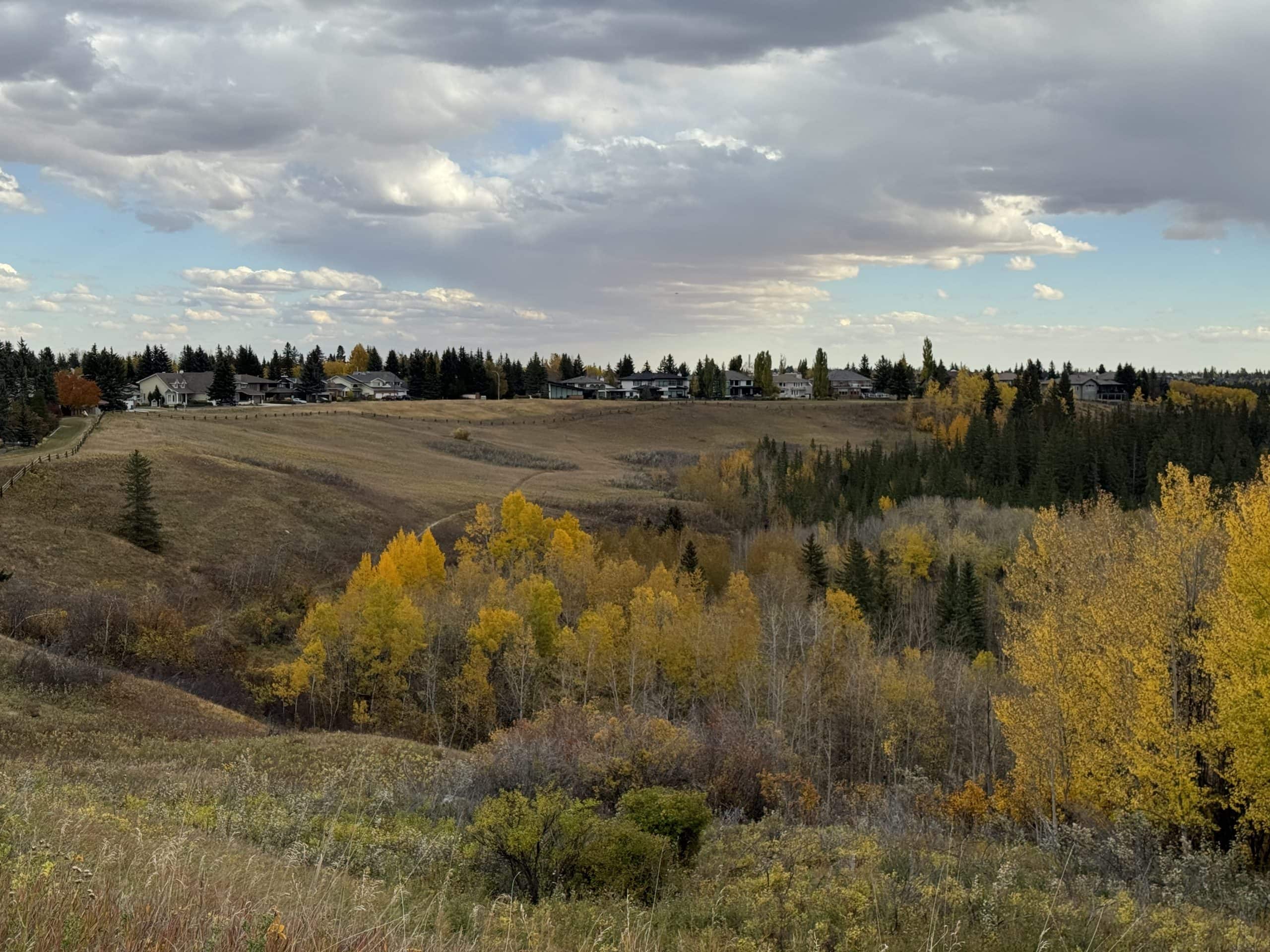 Ridge views in Woodbine overlooking rolling hills, fall trees, and nearby homes under a partly cloudy sky.