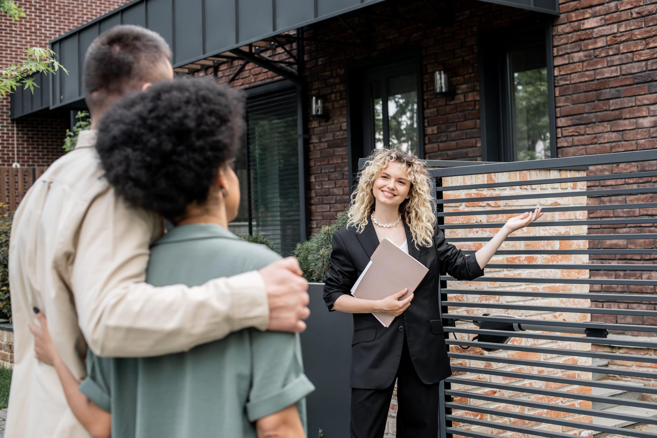 Realtor guiding a couple through a home showing in a modern Calgary neighbourhood.