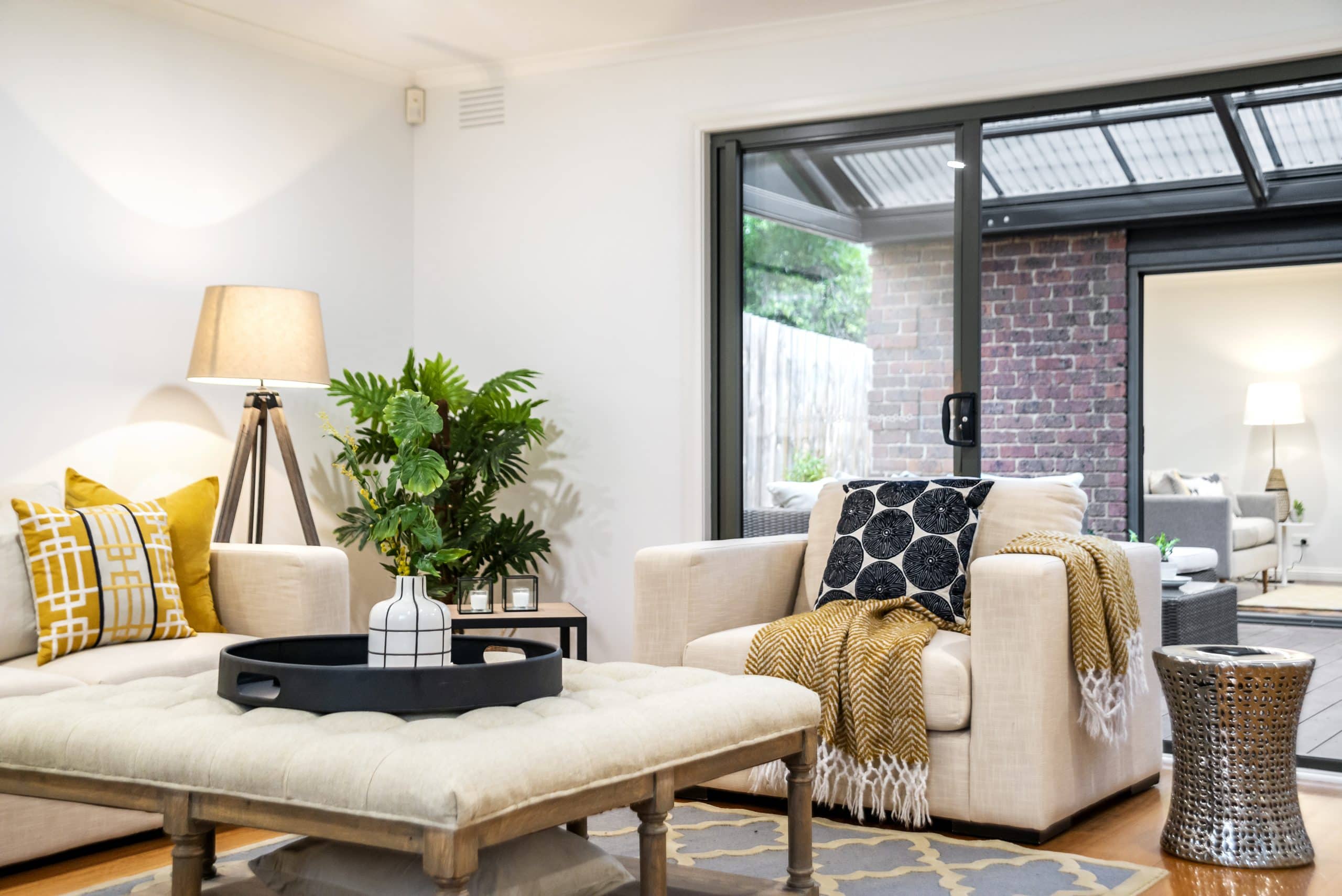 Bright staged living room with modern decor, neutral furniture, and indoor plants used to prepare a Calgary home for sale.

