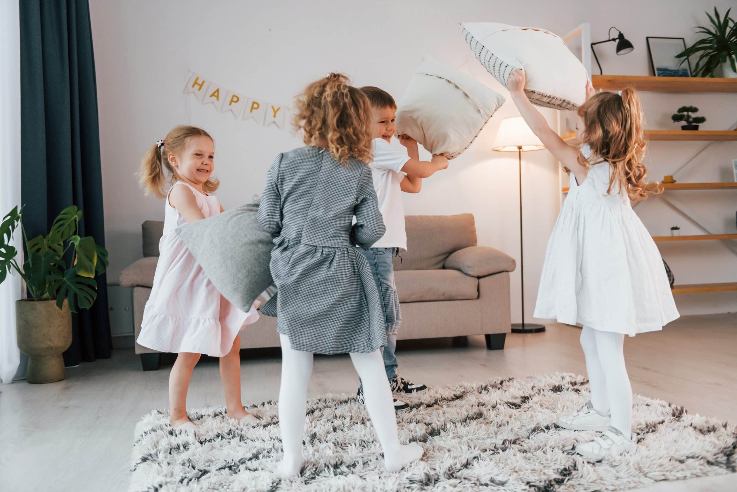 Children playing and throwing pillows in a living room, creating chaos and distractions during a home showing.