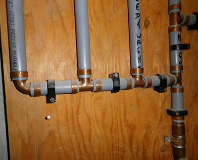 Grey Poly B plumbing pipes commonly found in Calgary homes built between the late 1980s and early 2000s, which can impact insurance, resale value, and buyer perception.