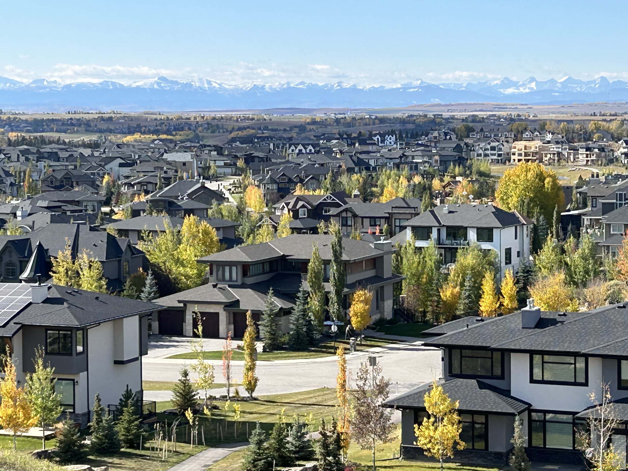 Calgary neighbourhood with modern homes and views of the Rocky Mountains, showcasing suburban communities popular with families relocating to Calgary.