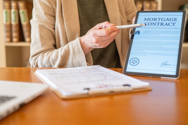 Person reviewing a mortgage contract on a tablet, illustrating the complete mortgage guide for buying a home in Calgary including approval and financing steps
