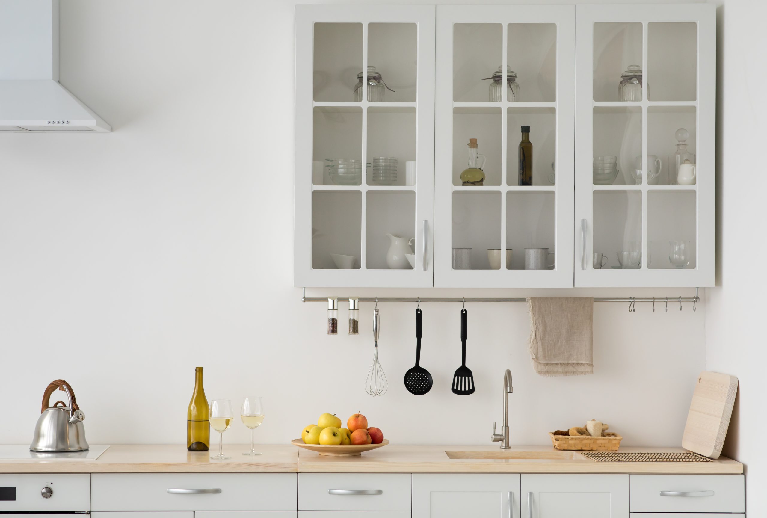 Minimalist kitchen with glass cabinet doors and clean layout that may lack practicality for everyday use