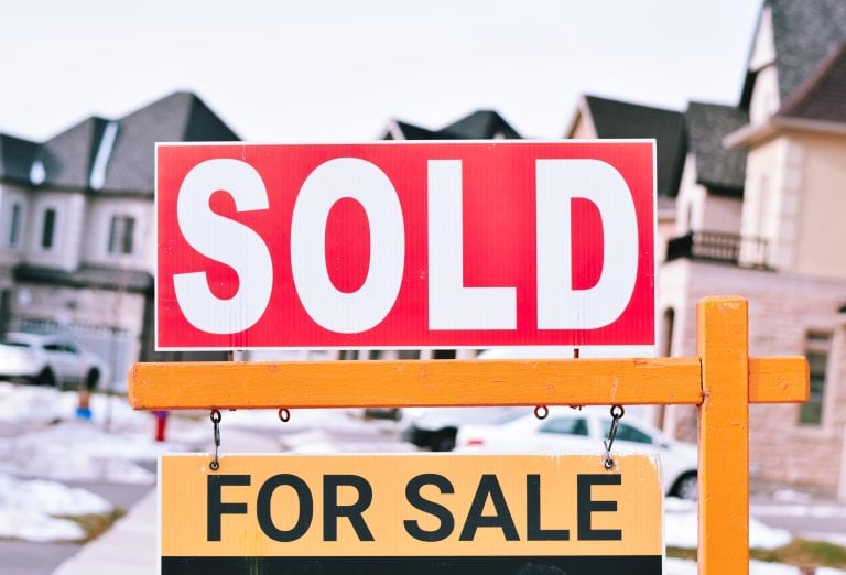 Sold home sign in a Calgary residential neighbourhood showing a successful property sale in the local real estate market.