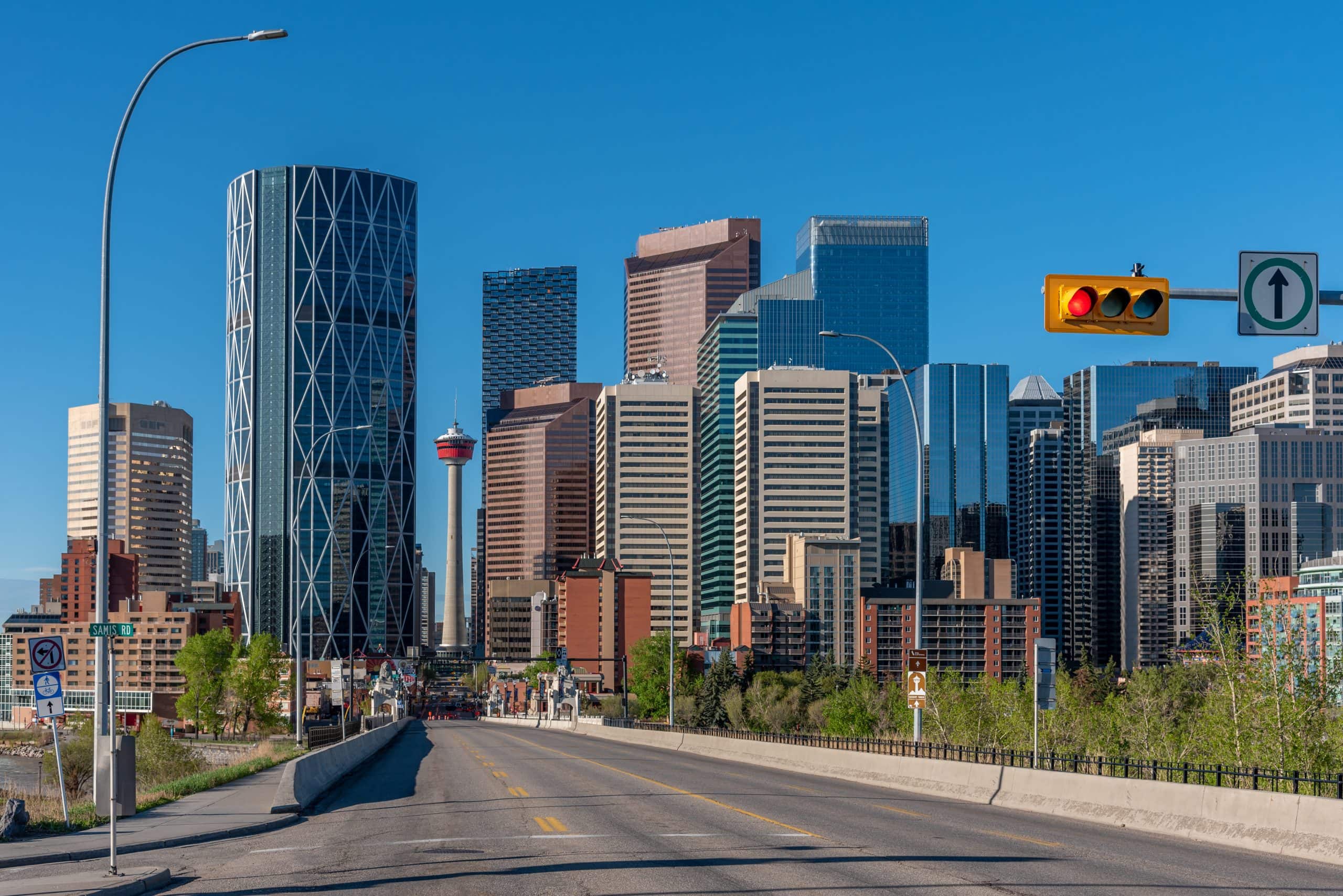 Calgary skyline on a clear spring day with downtown skyscrapers, the Calgary Tower, and an empty road leading toward the city centre in Alberta, Canada.