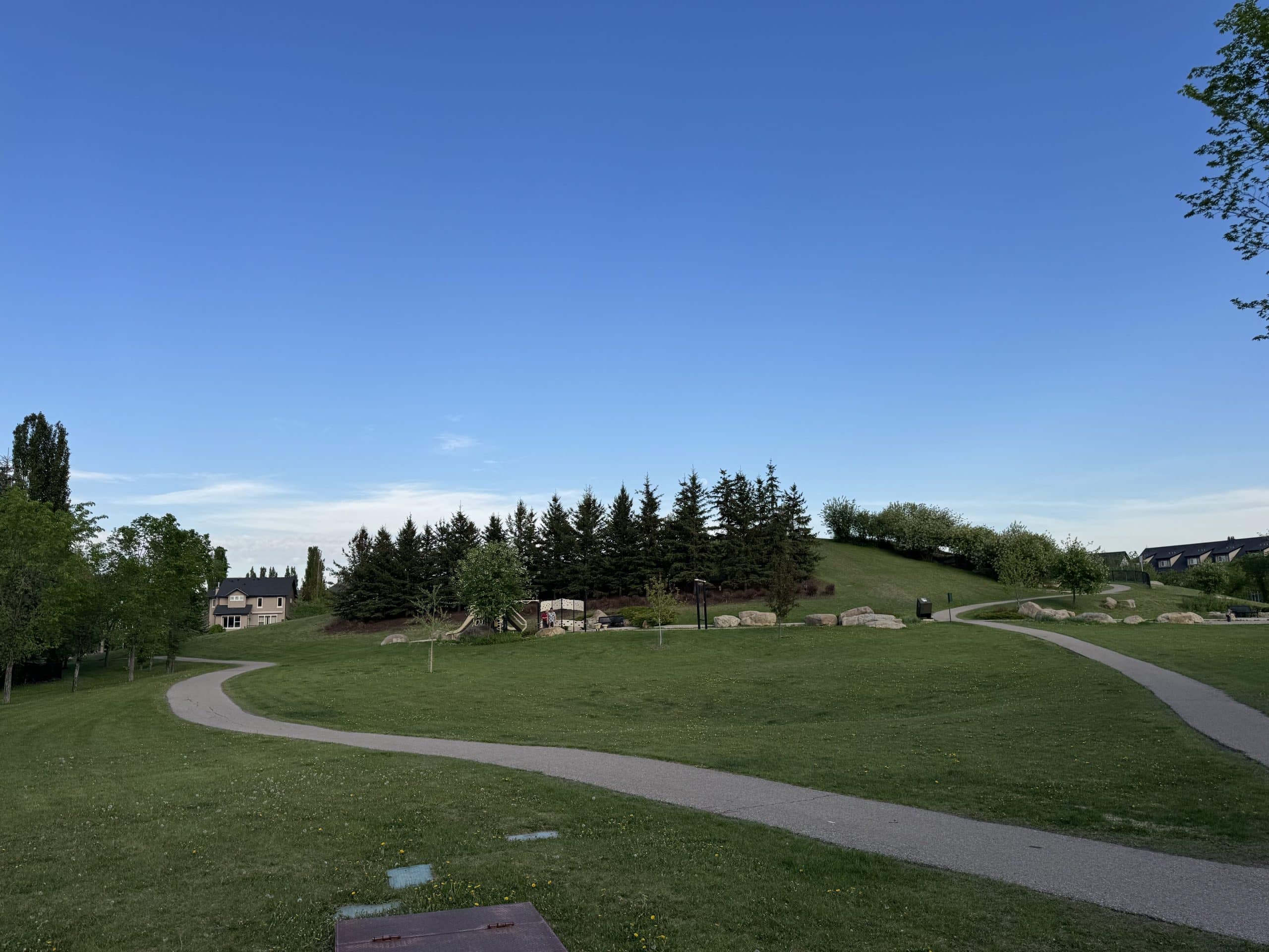 Pathways wind through one of McKenzie Towne's many parks and green spaces, highlighting the community's extensive trail network, family friendly design, playgrounds, and outdoor recreation opportunities for residents of all ages.
