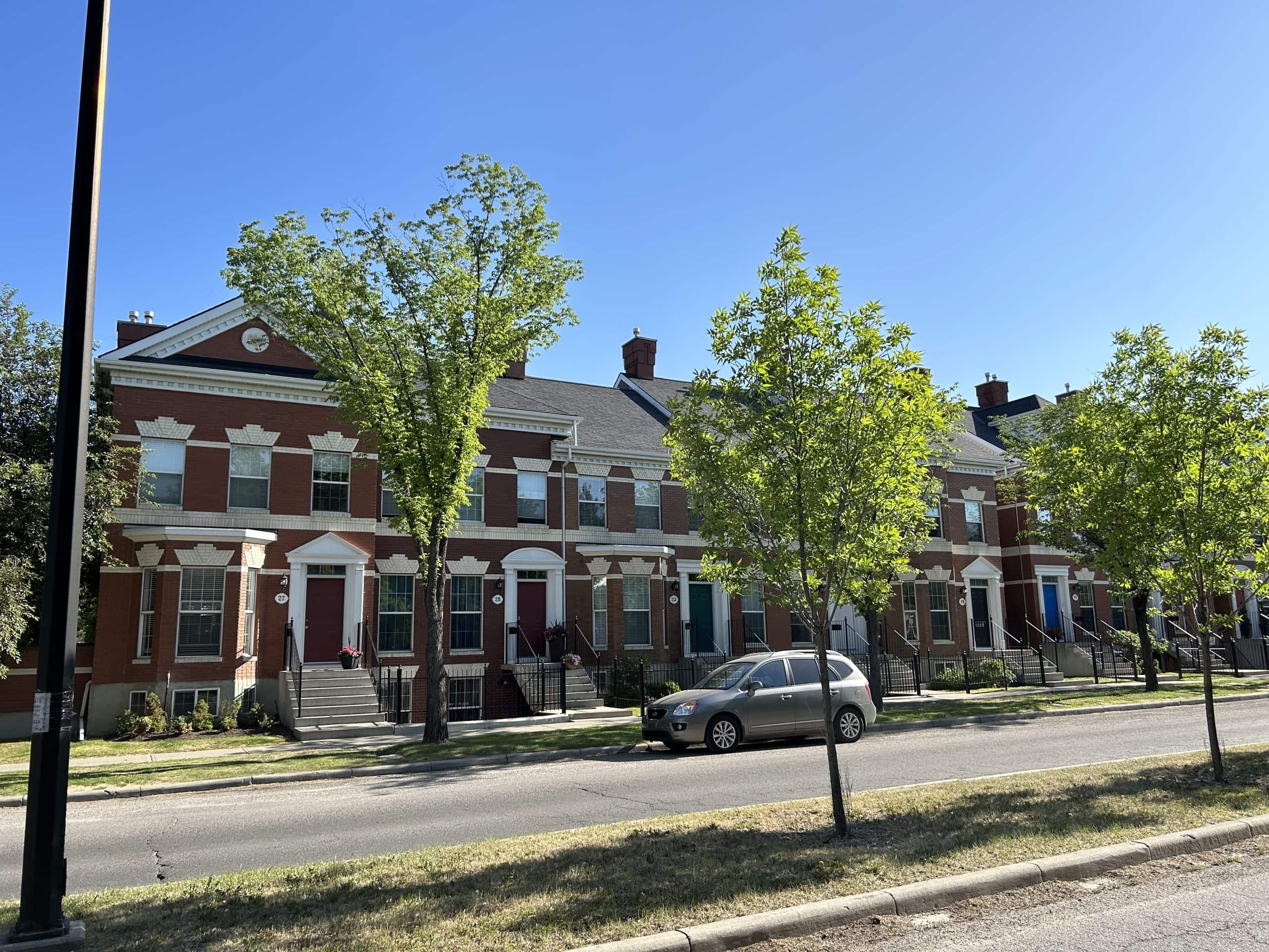 Brick townhomes in the Inverness area of McKenzie Towne featuring traditional architecture, mature landscaping, walkable streets, and a charming small town atmosphere in southeast Calgary.