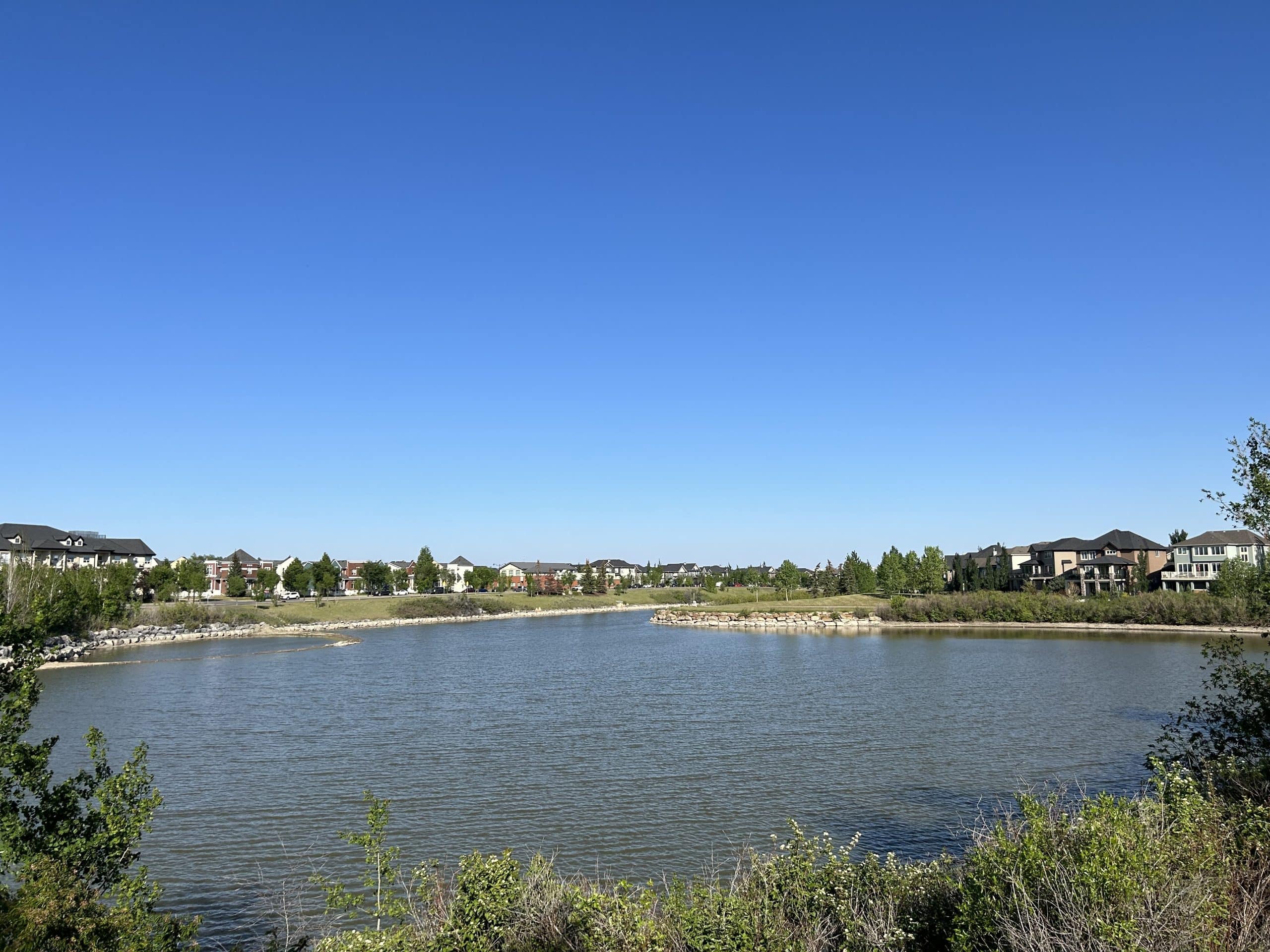Inverness Pond in McKenzie Towne featuring scenic waterfront views, walking paths, green space, and desirable homes backing onto one of the community's most popular outdoor gathering areas.