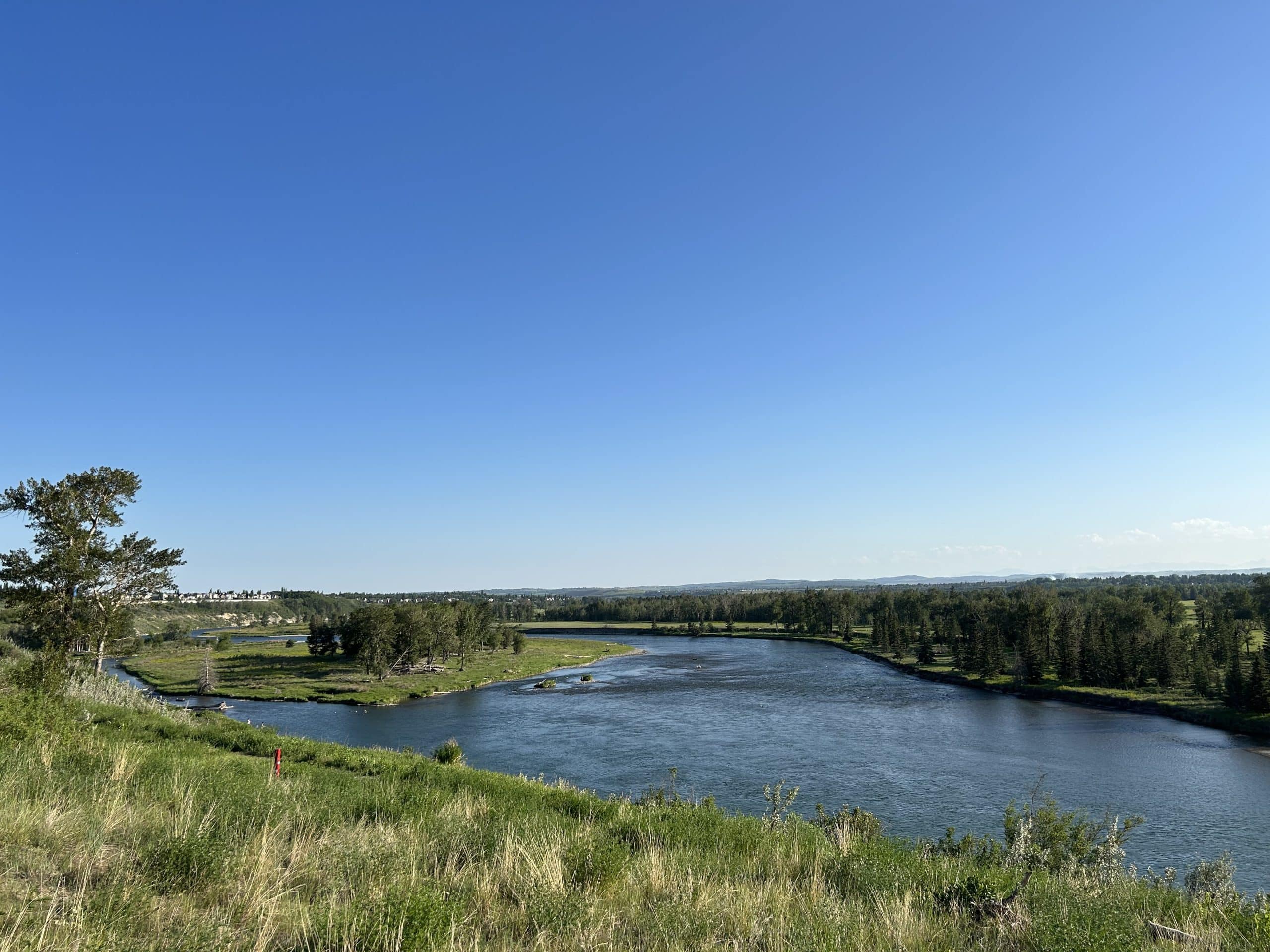 View from the McKenzie Lake ridge overlooking the Bow River and Fish Creek Provincial Park, showcasing the natural beauty, expansive river valley views, and prestigious homes that make this area one of southeast Calgary's most desirable locations.