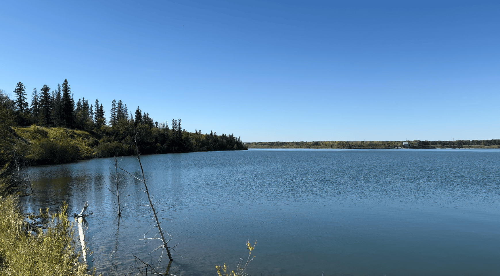 View of Calgary’s Glenmore Reservoir surrounded by peaceful natural landscapes, a major reason nearby luxury communities like Eagle Ridge, Pump Hill, and Bayview are so desirable.