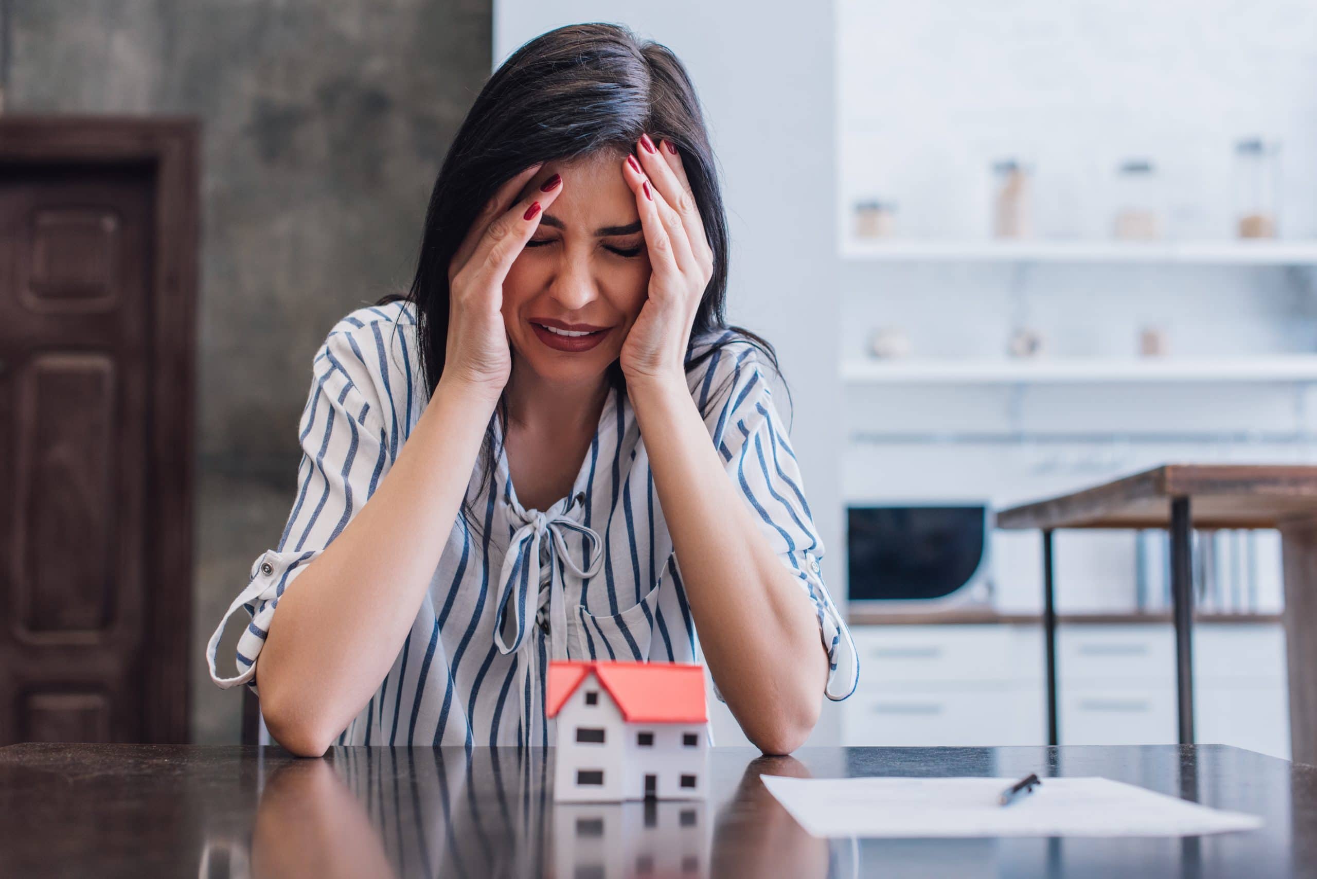 Calgary homeowner stressed over mortgage payments and rising housing costs after buying a home, representing home buyer remorse and financial pressure in Calgary real estate.