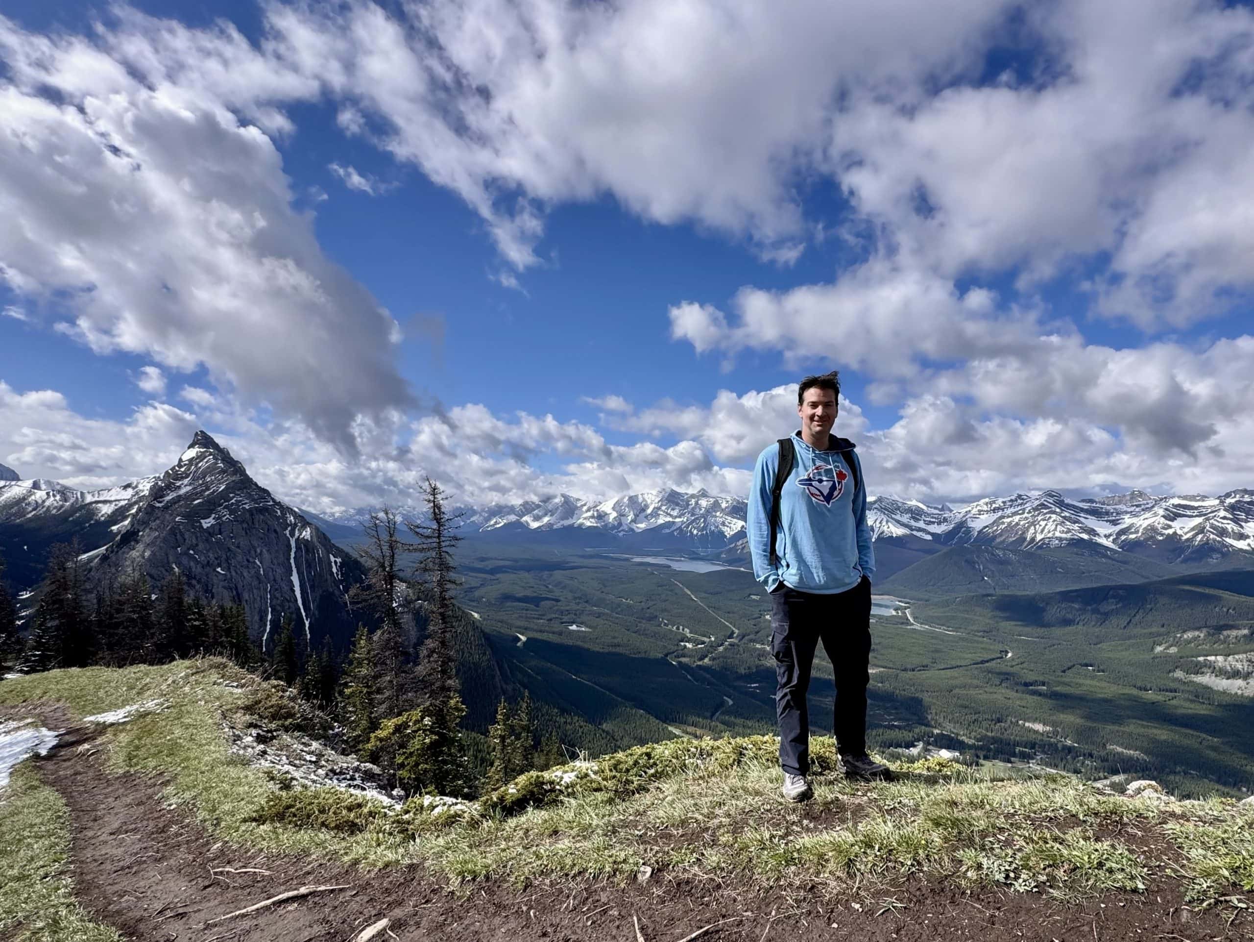Ryan standing on King Creek Ridge with Mount James Walker and the Opal Range stretching across the Kananaskis landscape.