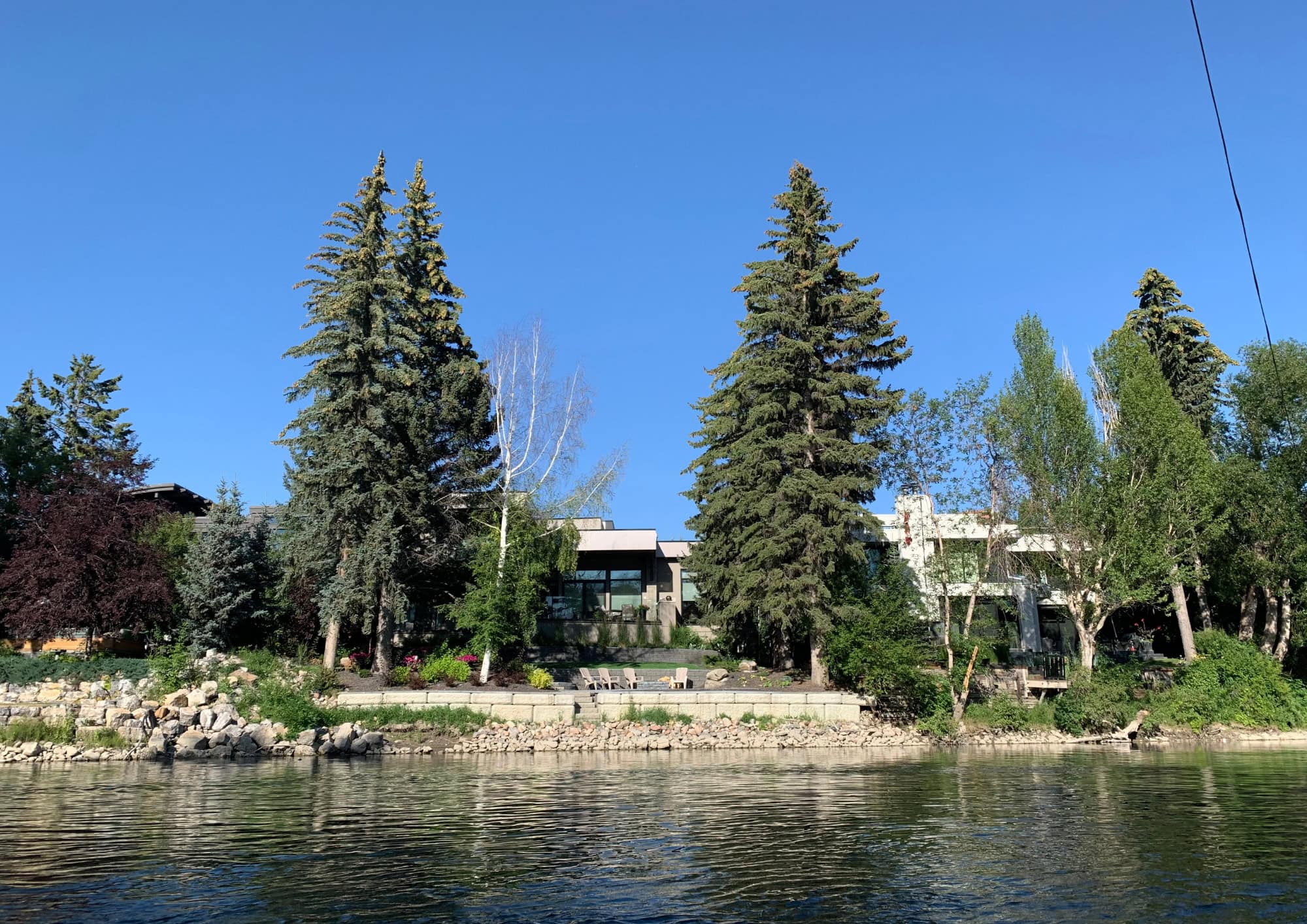 Luxury waterfront homes in Rideau Park and Roxboro along the Elbow River in Calgary, surrounded by mature trees and private riverfront properties.
