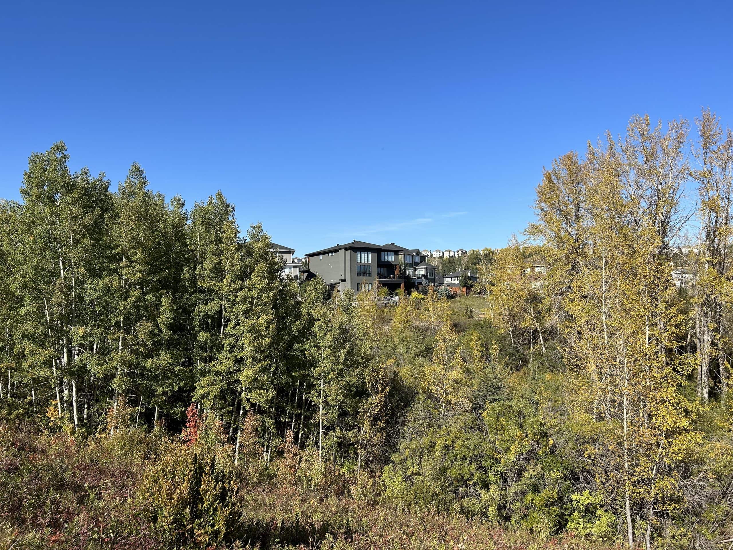 Tuscany homes overlooking a scenic ravine and mature green space in northwest Calgary, Alberta.