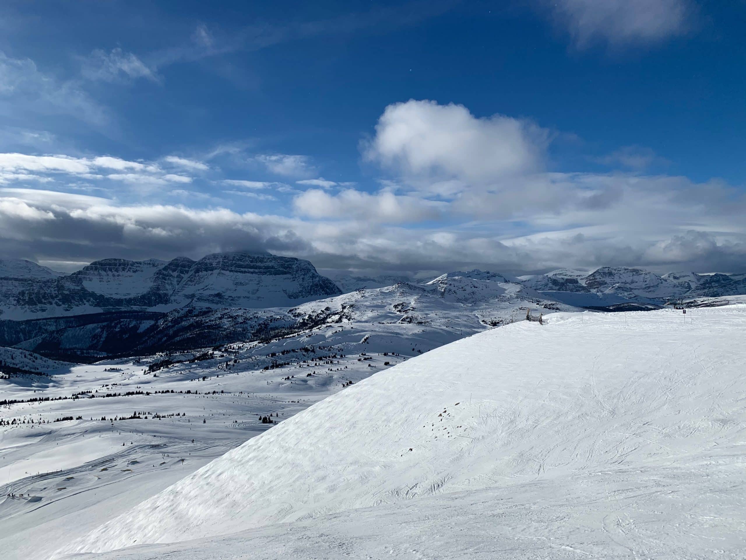 Panoramic winter views across the ski slopes and snow covered Canadian Rockies at Sunshine Village near Banff, Alberta.