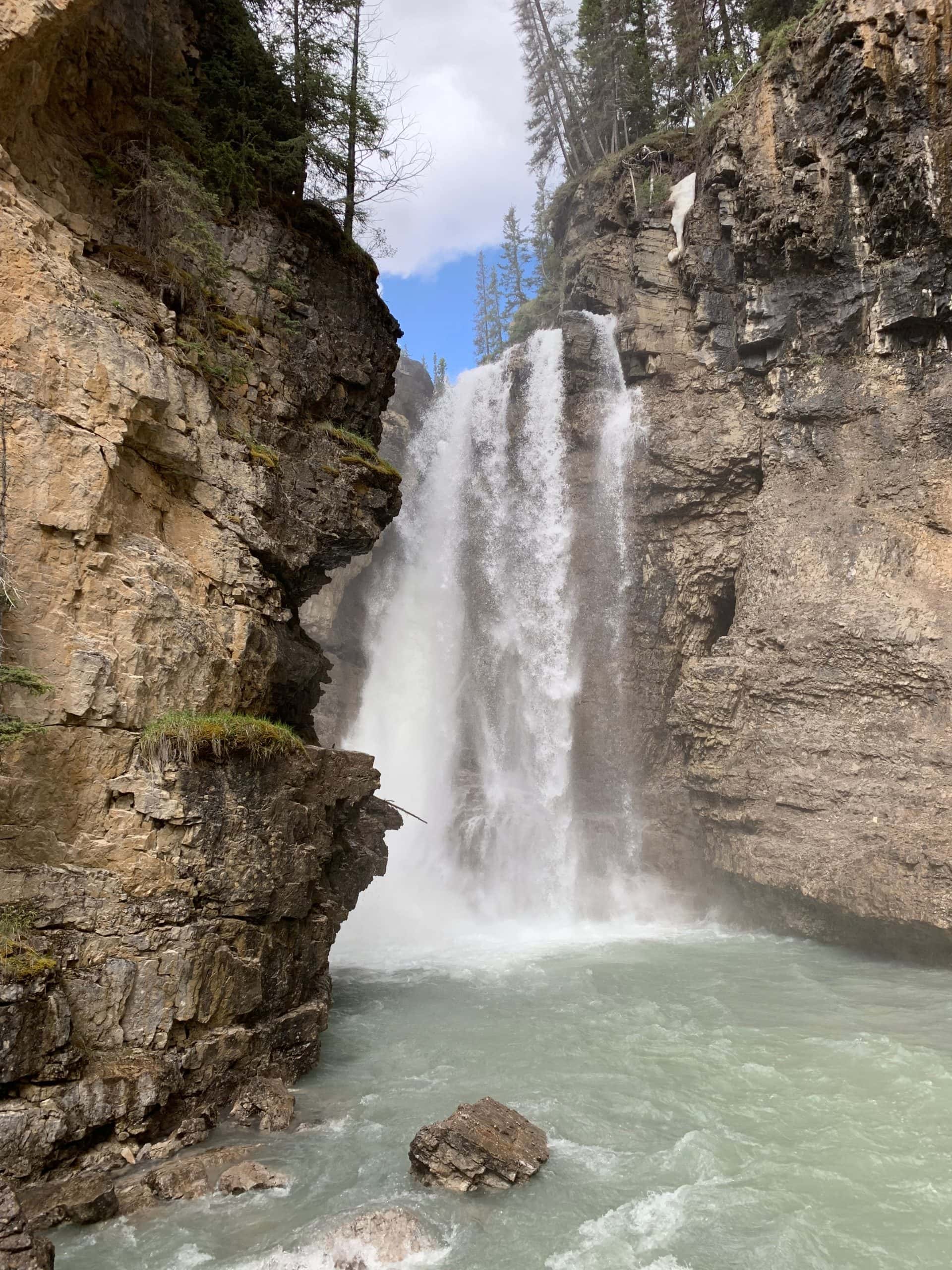 Waterfall rushing through the steep rock walls of Johnston Canyon in Banff National Park, Alberta.