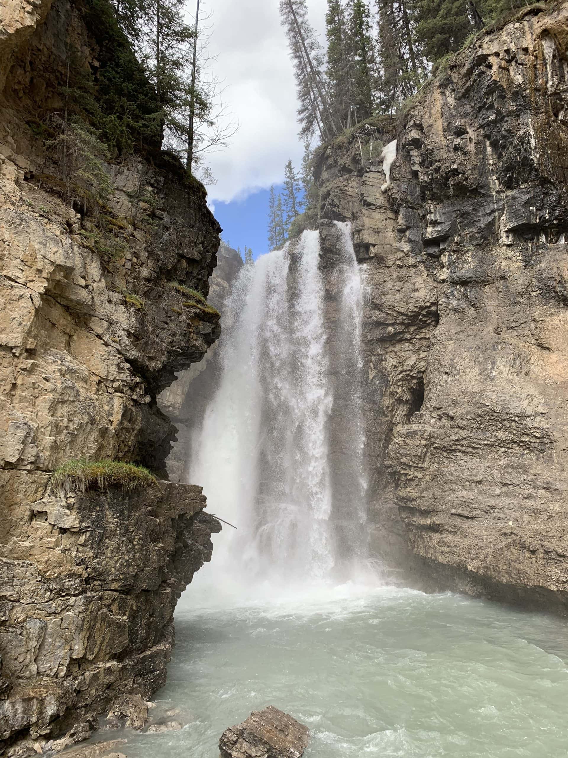 Johnston Canyon waterfall flowing through a rocky gorge in Banff National Park, Alberta.
