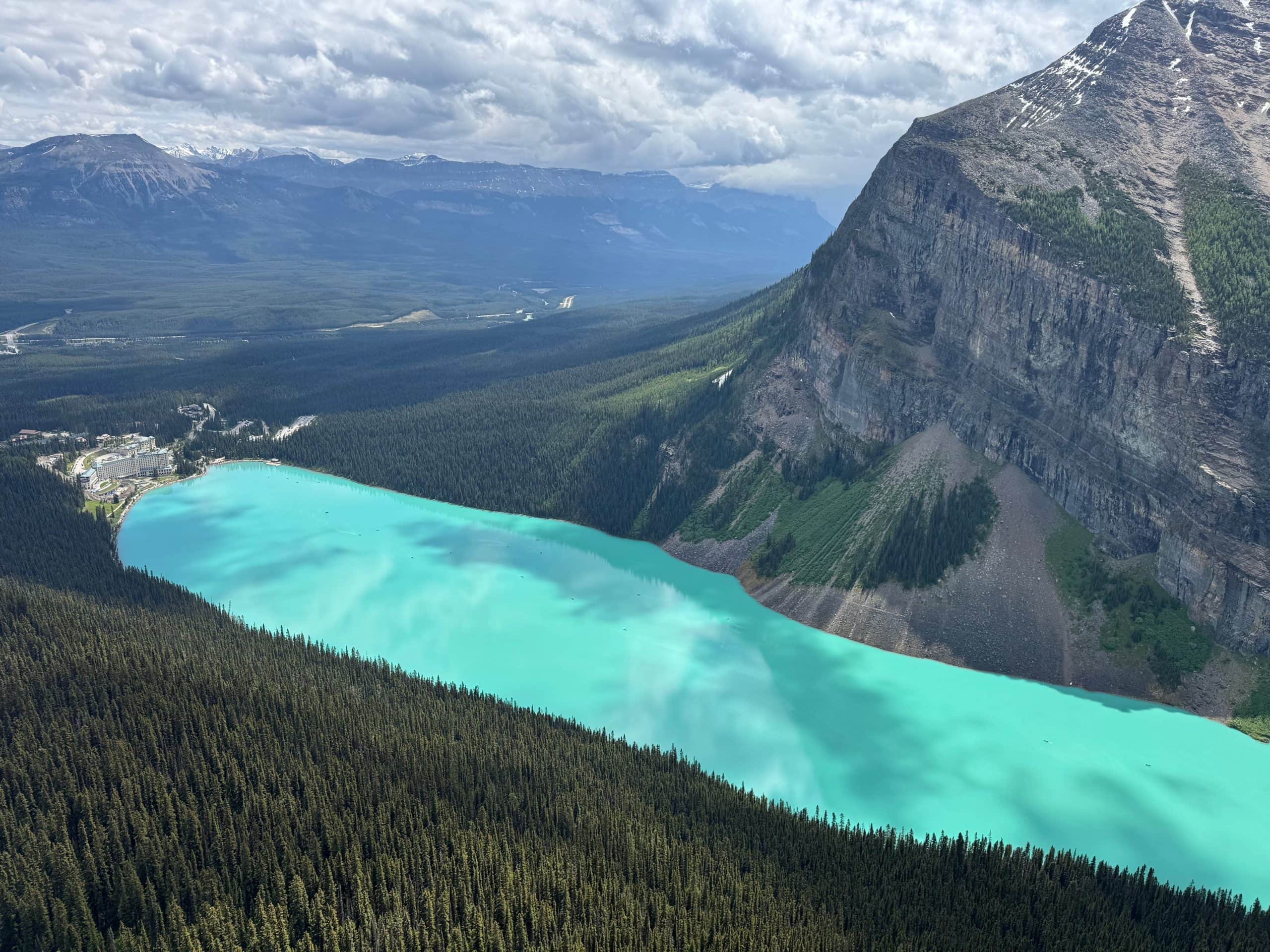 View of turquoise Lake Louise and the Fairmont Chateau Lake Louise from the Big Beehive hike in Banff National Park, Alberta.
