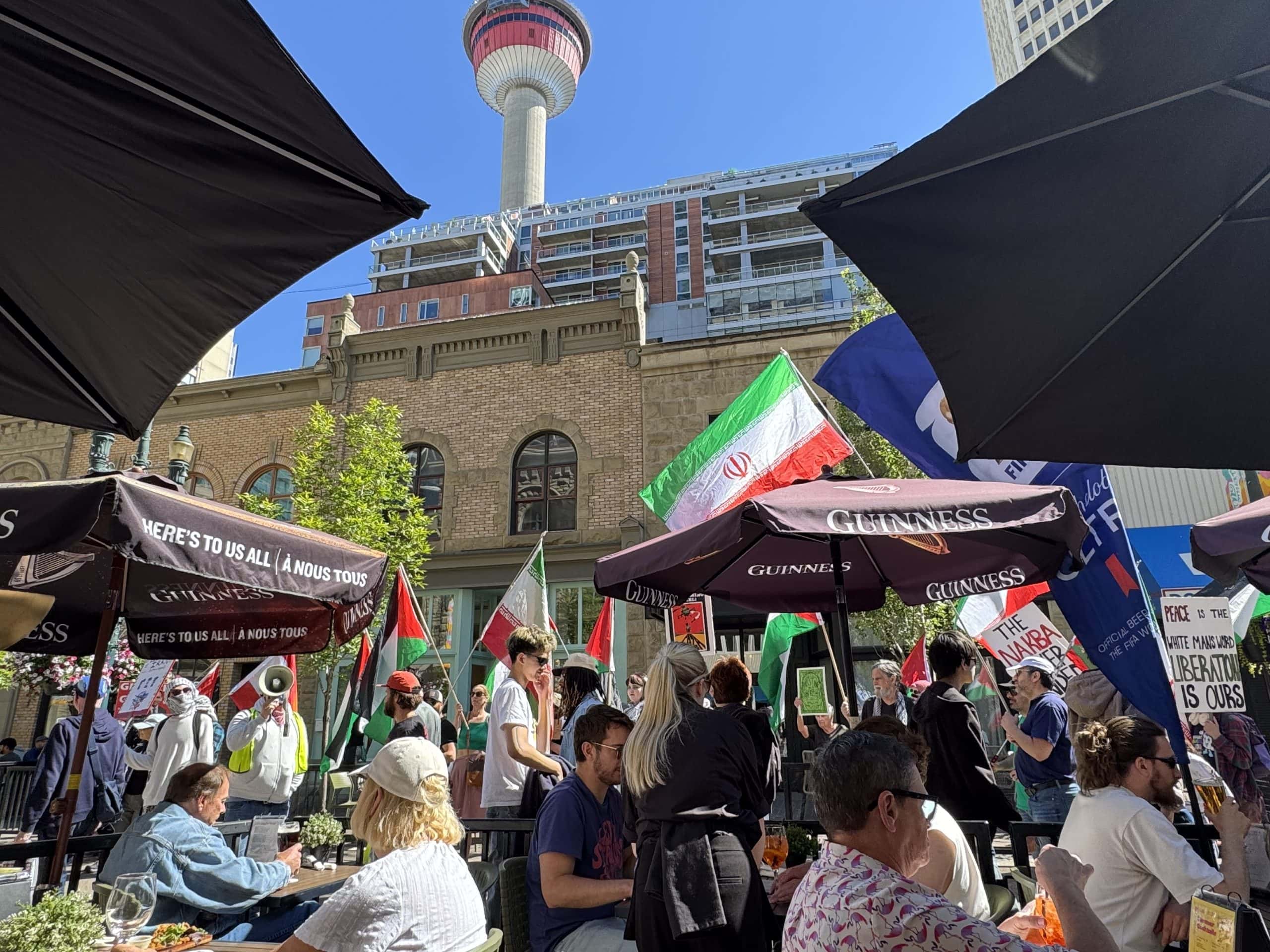 Busy downtown Calgary patio beneath the Calgary Tower on a sunny summer day.