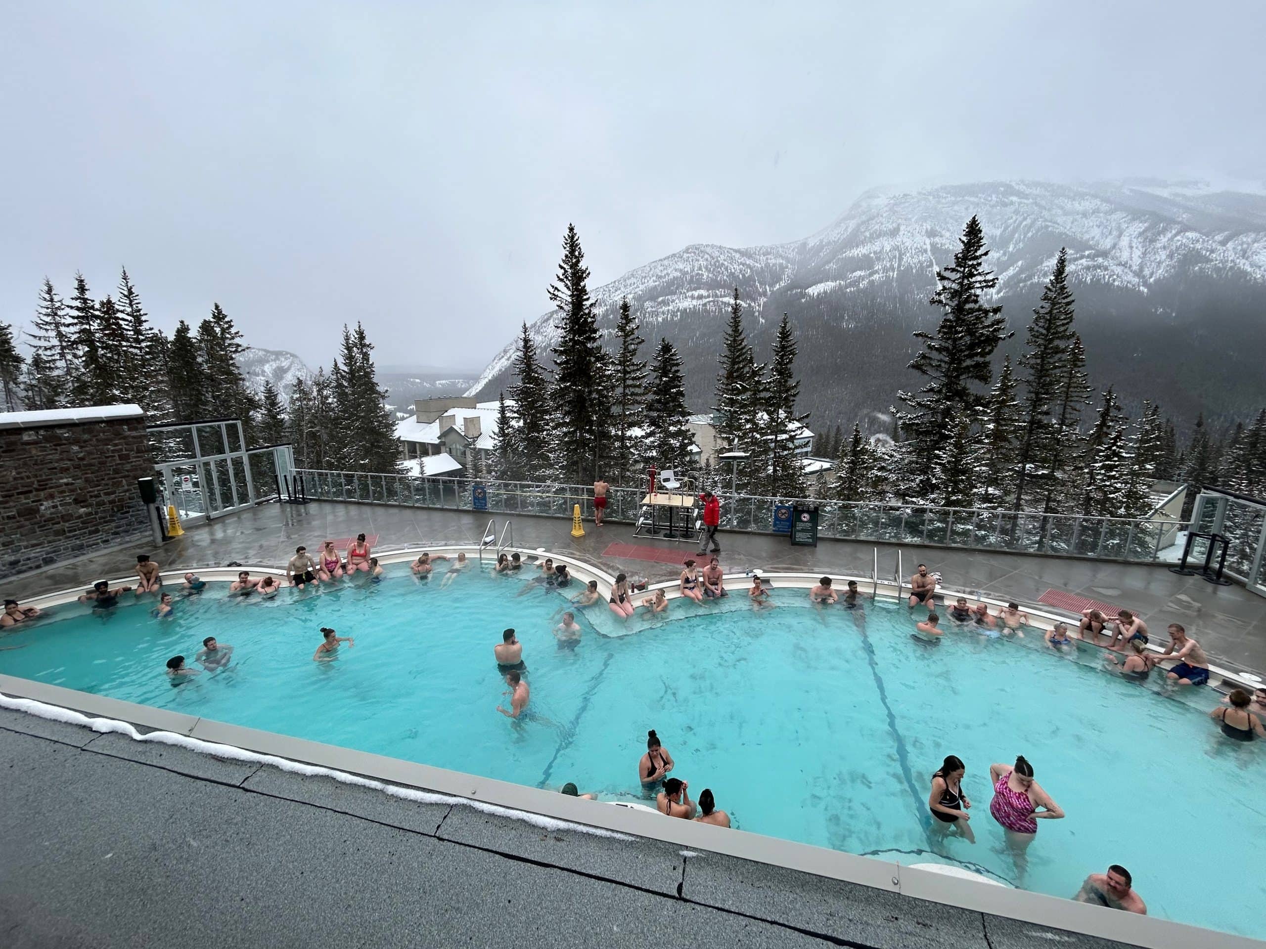 Outdoor pool at Banff Upper Hot Springs overlooking the snow covered Rocky Mountains in Banff National Park, Alberta.