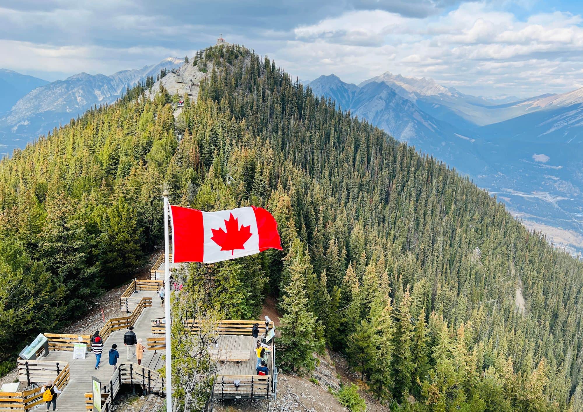 Canadian flag overlooking the Rocky Mountains from the summit of Sulphur Mountain above Banff, Alberta.