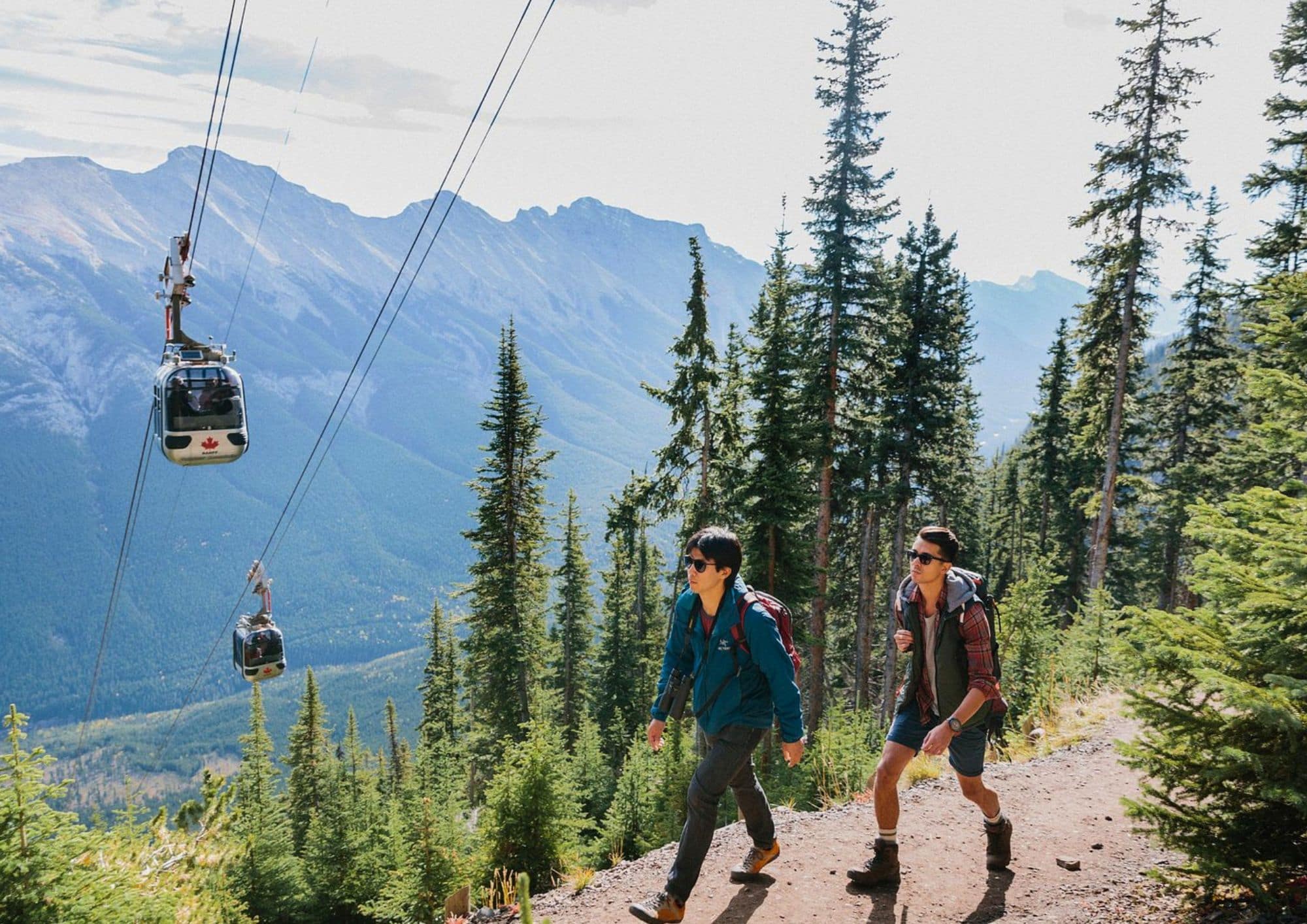 Banff Gondola climbing Sulphur Mountain above Banff, Alberta, with hikers and panoramic views of the Canadian Rockies.