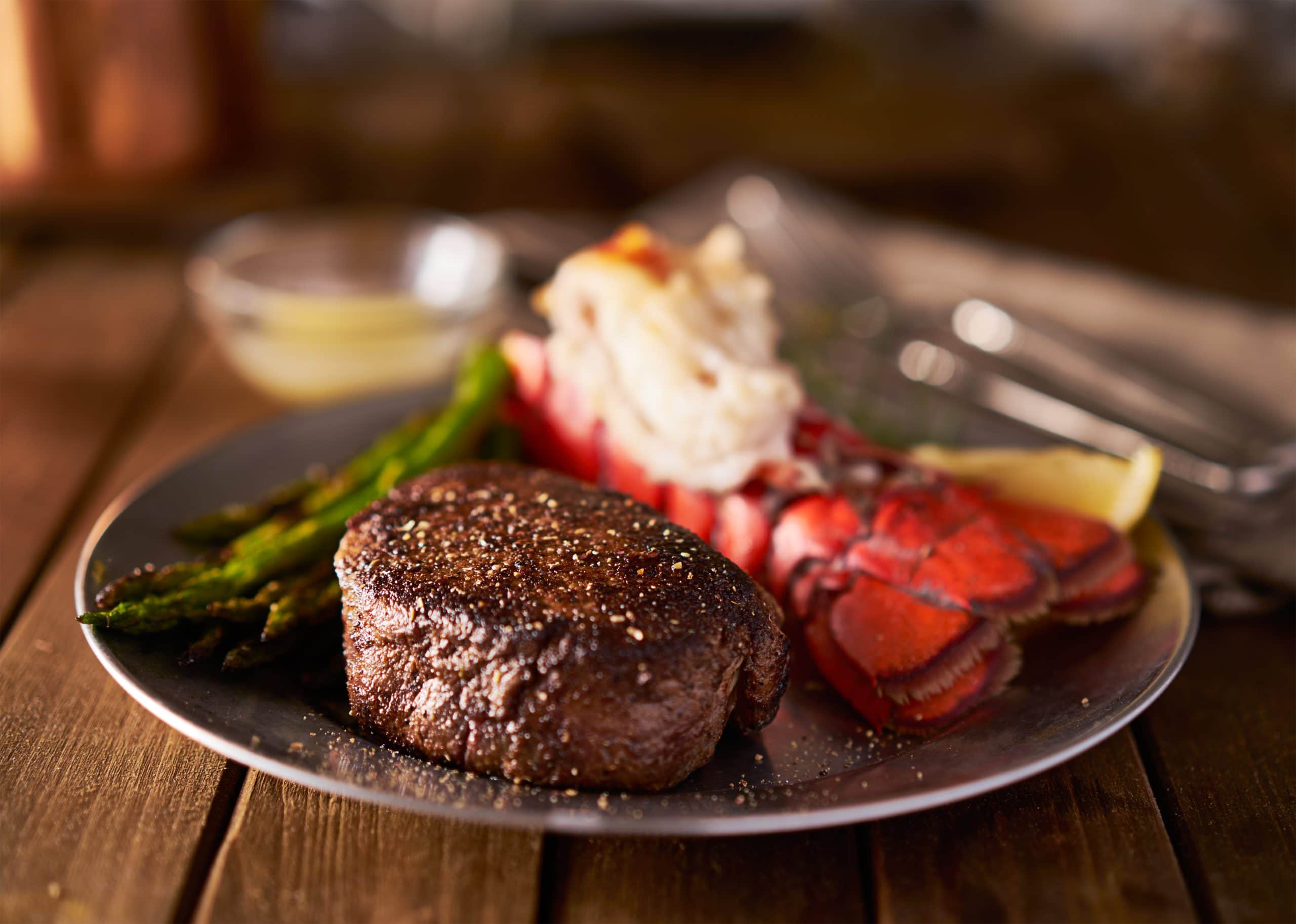 Steak and lobster dinner with grilled asparagus, a classic surf and turf meal.