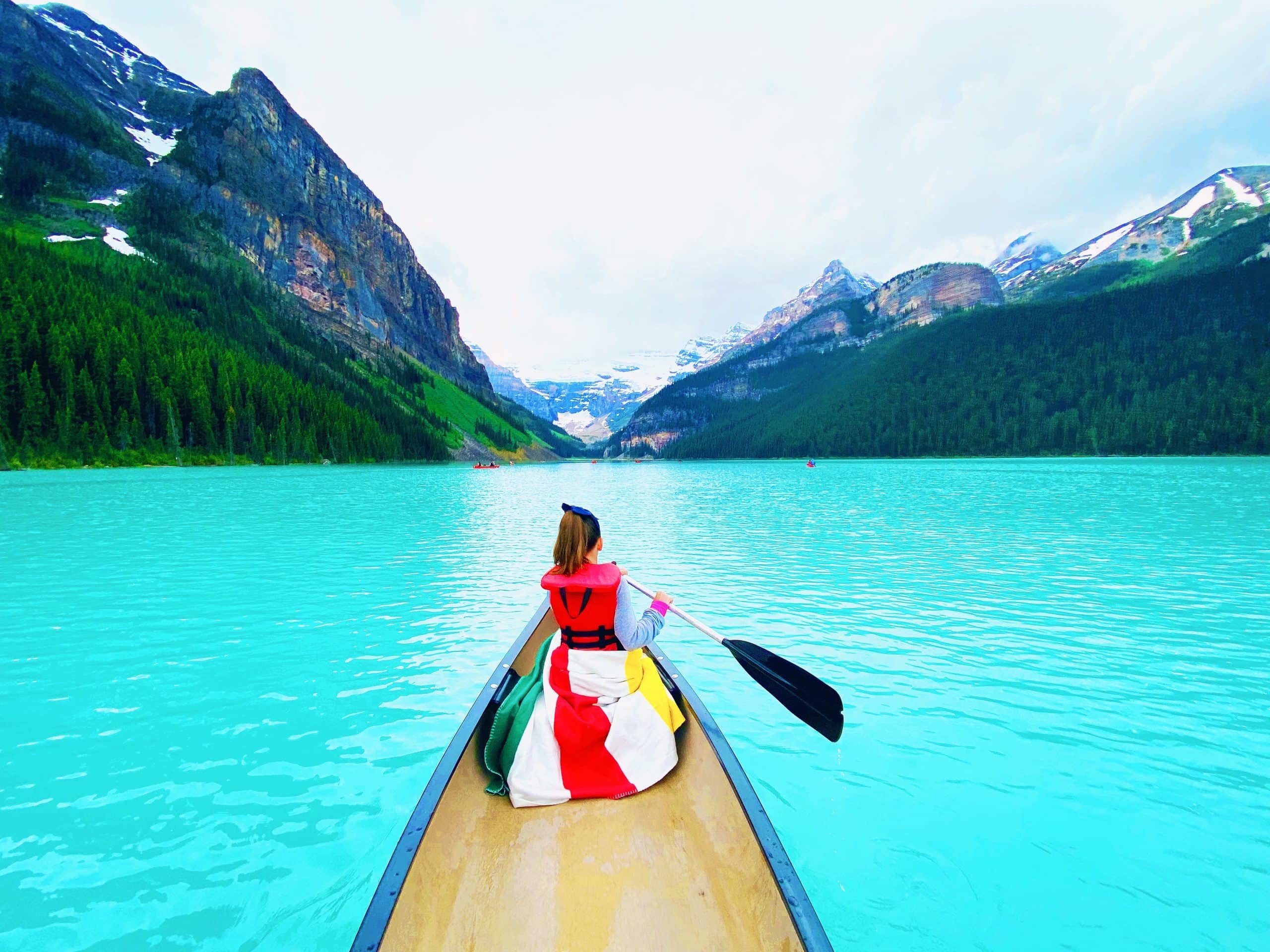 Canoeing on the turquoise waters of Lake Louise surrounded by the Canadian Rockies in Banff National Park, Alberta.